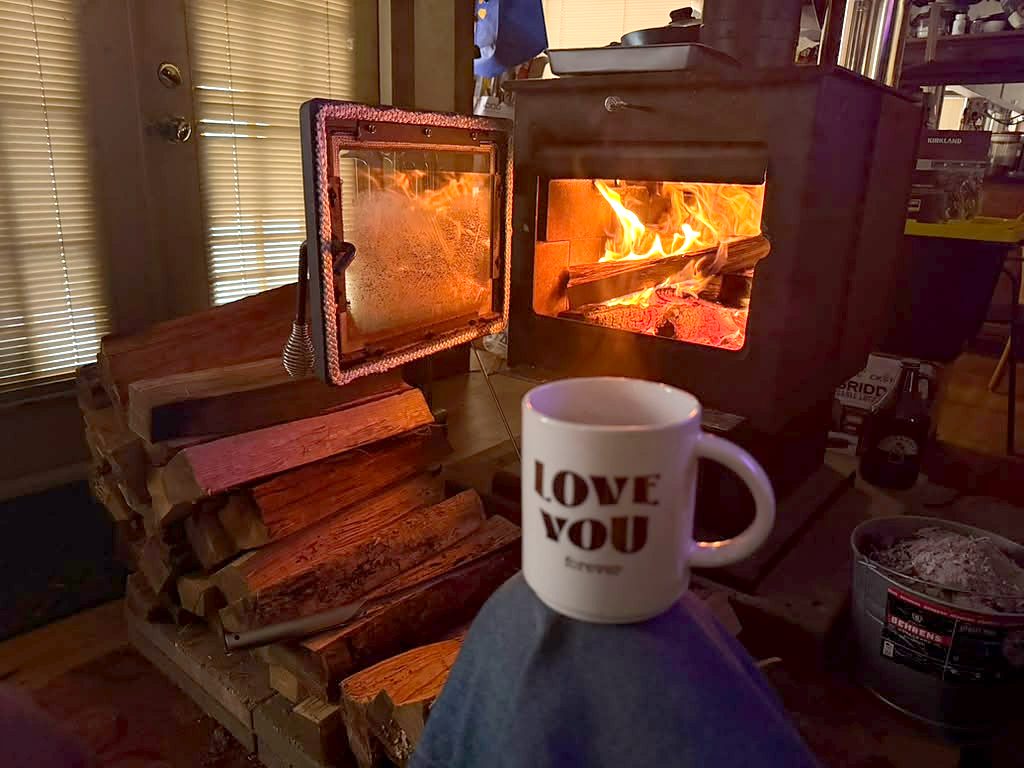 Wood stove burning beside a coffee mug in the lounge